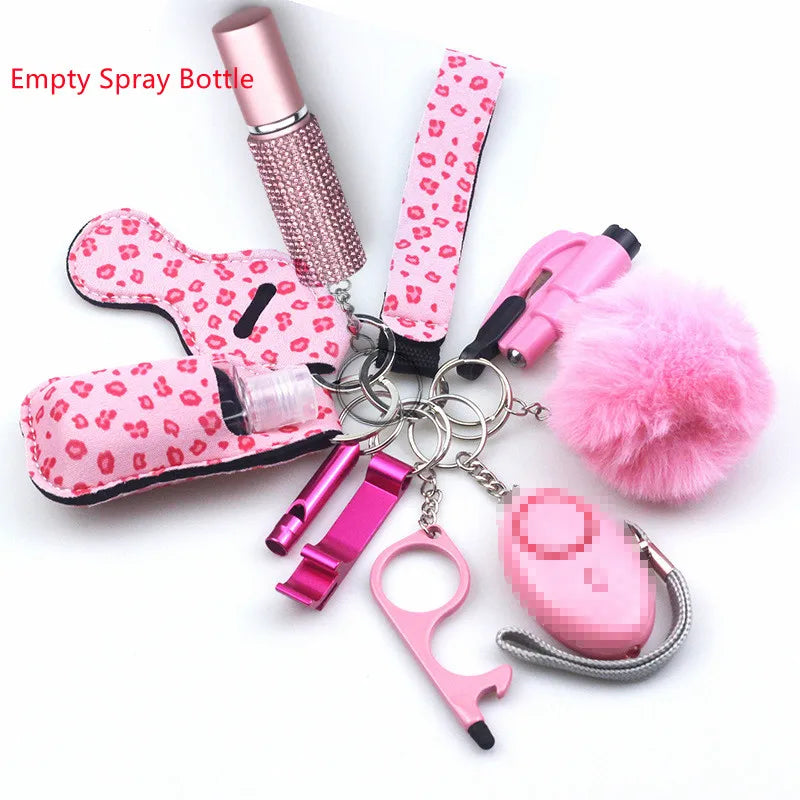 Accessory key ring with wrist strap, diamanté covered empty spray bottle for fragrance or hand sanitiser, a 130 decibel alarm with a bright flashlight, bottle opener, bottle for 30 ml liquid, lip balm holder, window breaker, fluffy pompom, whistle, and a non-touch key.