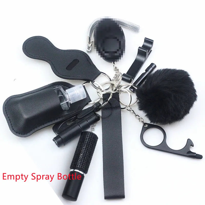 Black self defence key ring: wrist strap, diamanté covered empty spray bottle for pepper spray, a 130 decibel alarm with a bright flashlight, bottle opener, bottle for 30 ml hand sanitiser, lip balm holder, window breaker, fluffy pompom, whistle, and a non-touch key.