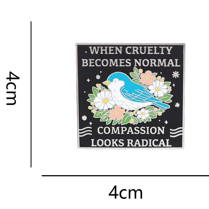 A square enamel pin with dimension lines indicating 4 cm by 4 cm. The product has a black background with a blue bird, white flowers, green leaves, and white text reading 'WHEN CRUELTY BECOMES NORMAL COMPASSION LOOKS RADICAL.