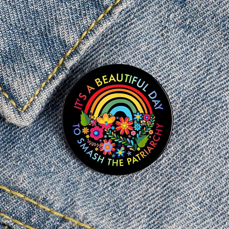 Show your pride with the "It's A Beautiful Day To Smash The Patriarchy" badge, featuring a rainbow and colorful flowers—a unique feminist pick for your denim or bag!.