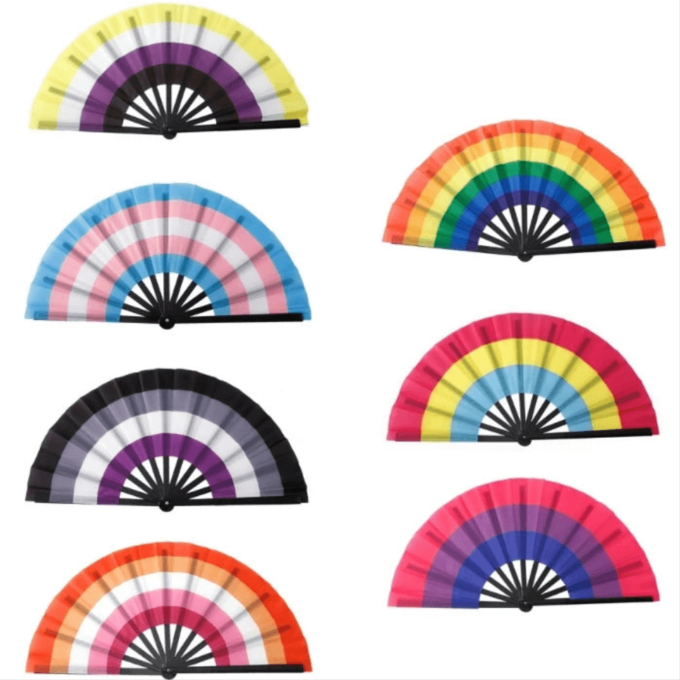 An image features Very Large Folding Personal Fans from Gay Skate, each representing different pride flag identities. The colors are vibrant rainbow spectrums, with each fan displaying a unique design reflecting the Rainbow, Lesbian, Bi, Trans, Non-binary, Pansexual, and Asexual pride flags. Drag queen fans