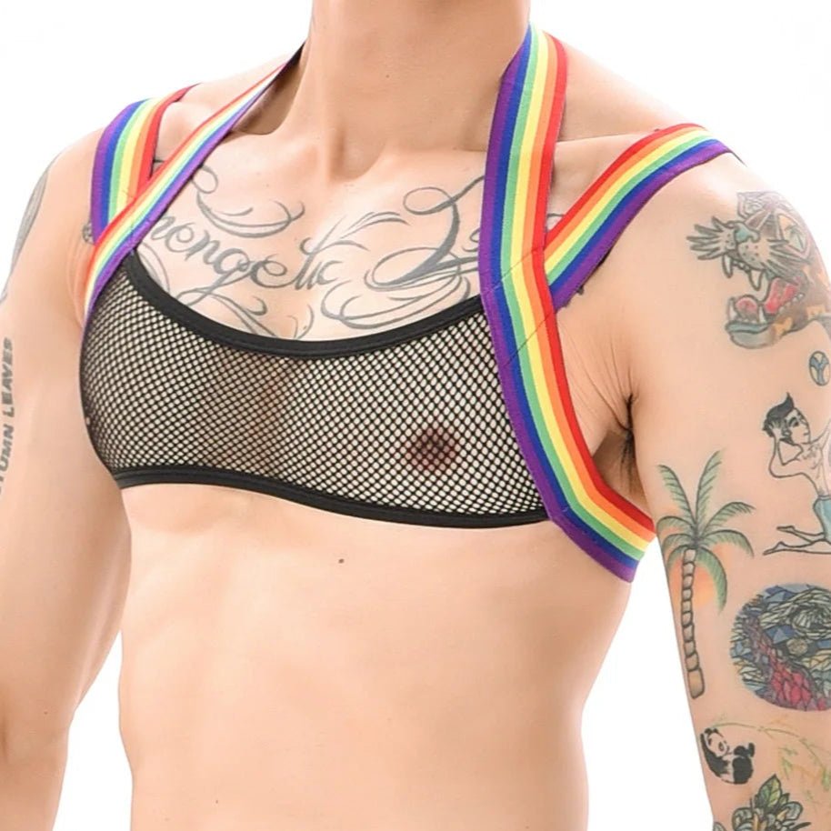 A person shows off the Gay Skate Mesh Harness Set with rainbow straps and a sheer mesh top. Sexy gay Chest Harness showcases a vibrant rainbow design, embodying the spirit of queer pride. Leather pride, Fetish, BDSM, Mardi Gras Outifit for twinks, poof, fag, gay guy, queers and lesbians. Lingerie for men