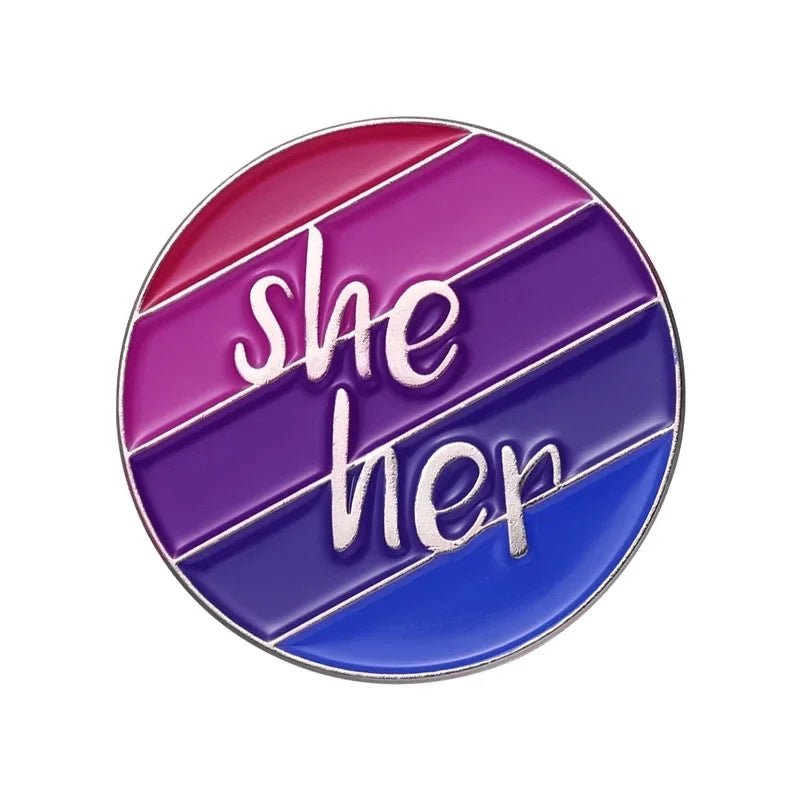 The "Pride Flag Fist" enamel pin features diagonal pink, purple, and blue stripes with "she her" in white script—an LGBTQ+ Bi Pride accessory perfect for expressing identity.