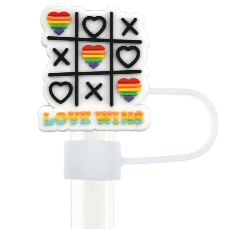 A tic-tac-toe accessory with rainbow heart and 'X' symbols says "LOVE WINS" in radiant hues. It's attached to a white strap, ideal for fans of the Pride straw topper designed to fit Stanley Cup straws.