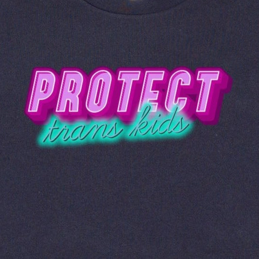 The Gay Skate's "Protect Trans Kids - original design - locally printed crop tee" is a black crop top t-shirt that proudly displays the text "PROTECT trans kids" in bold, vibrant pink and teal letters across the chest. The eye-catching font and incorporation of transgender pride flag colors make it a standout piece in queer skate and streetwear.