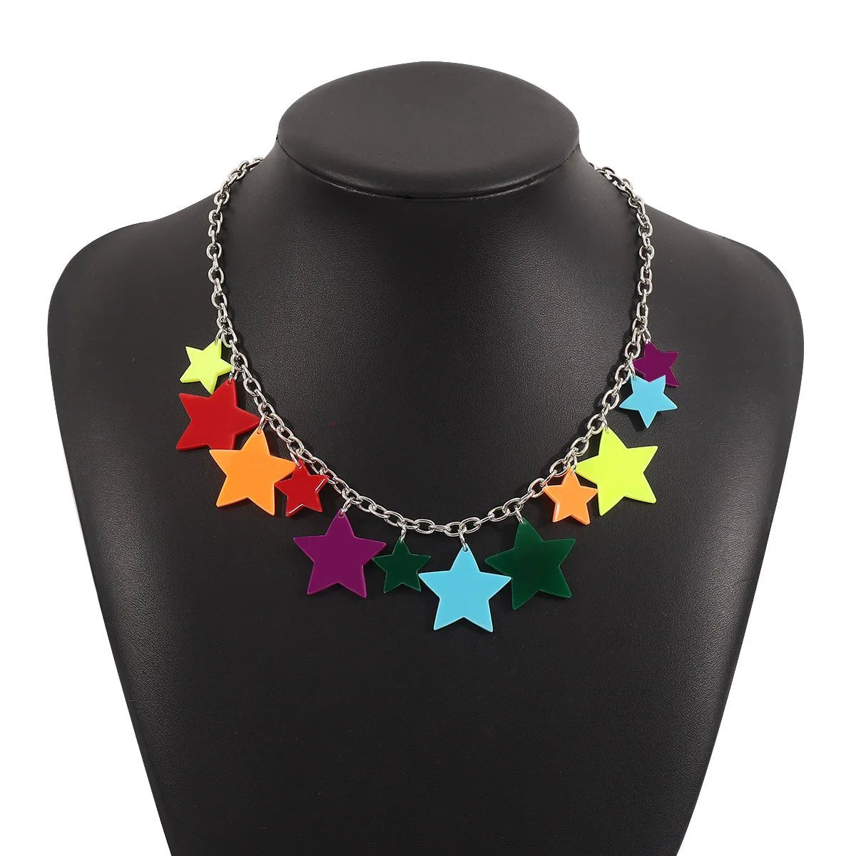 The Rainbow Pride Acrylic Necklace, available in 3 designs, features a silver chain adorned with colorful acrylic star charms of various sizes and is shown on a black jewelry bust.