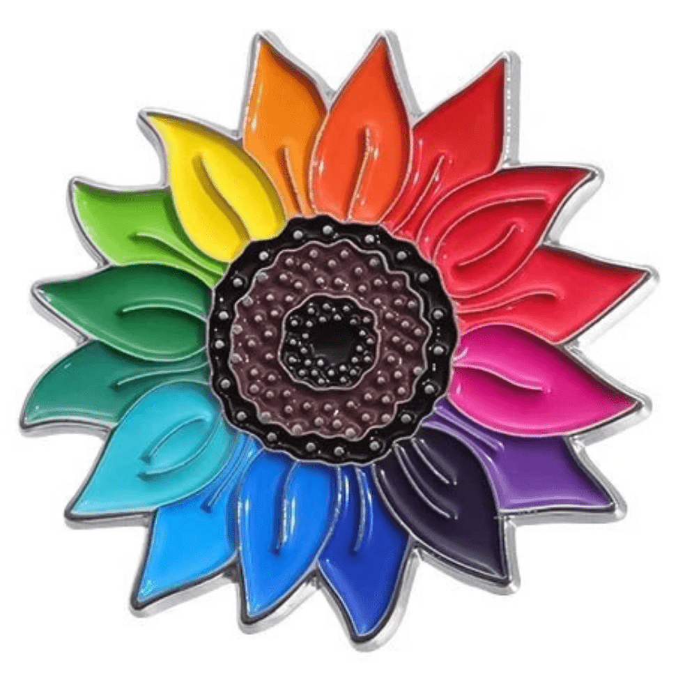 The Rainbow Sunflower enamel pin is a vibrant pride accessory featuring multicolored petals arranged in a circular pattern representing the colors of the rainbow, symbolizing inclusivity and unity, surrounding a textured dark center.