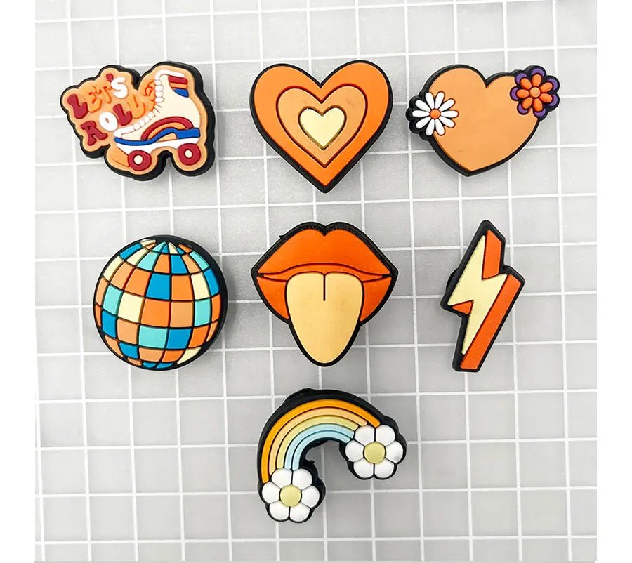 A grid of colorful Retro Roller Skate theme Shoe Charms: quad skate, heart, globe, lips outstretched, lightning bolt, and rainbow with flowers. Each charm showcases vintage shades of orange, blue, and yellow—evoking vibrant orange jibbitz.