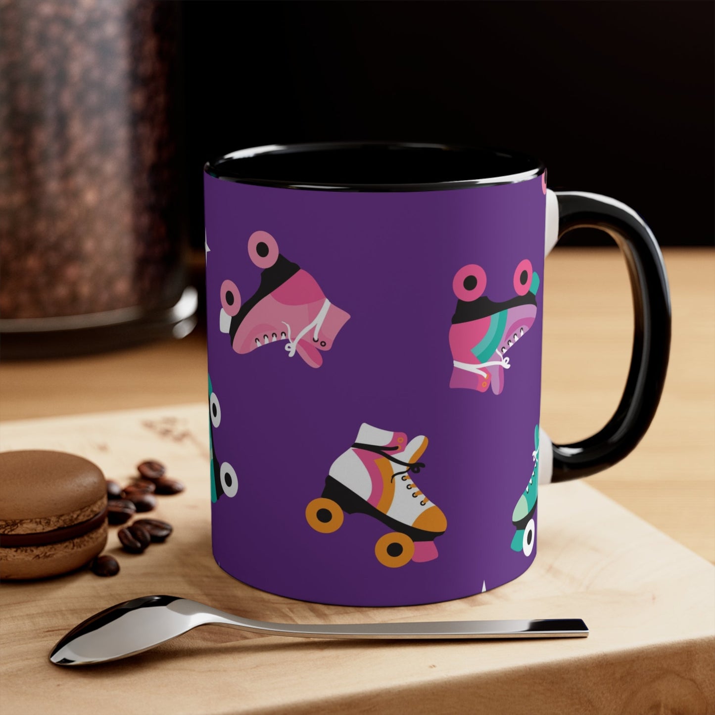 The Printify Roller Skates with a purple background - cute colourful accent mug features a white ceramic coffee mug with a pink handle and interior. Its design is adorned with various colorful roller skate illustrations against a vibrant purple background, showcasing skates in different styles and colors for a playful touch.
