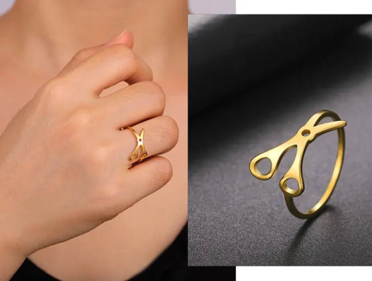 The Stainless Steel or Gold Scissor Ring for sapphic, WLW, and lesbian pride is shown worn on a hand in one photo and displayed solo on a dark surface—perfect for lovers of unique pride accessories.