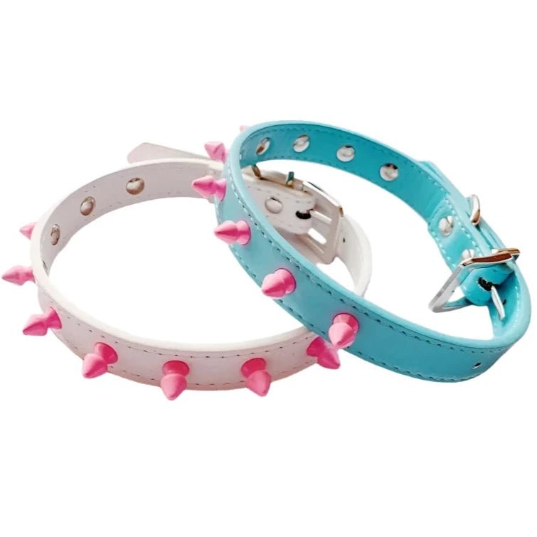 The Studded Pastel Choker Collar by Gay Skate offers two charming designs: one comes in white with pastel pink spikes, and the other features a blue collar decorated with small pink studs. Each choker is adjustable through multiple holes and includes a sturdy metal buckle to ensure a secure fit.