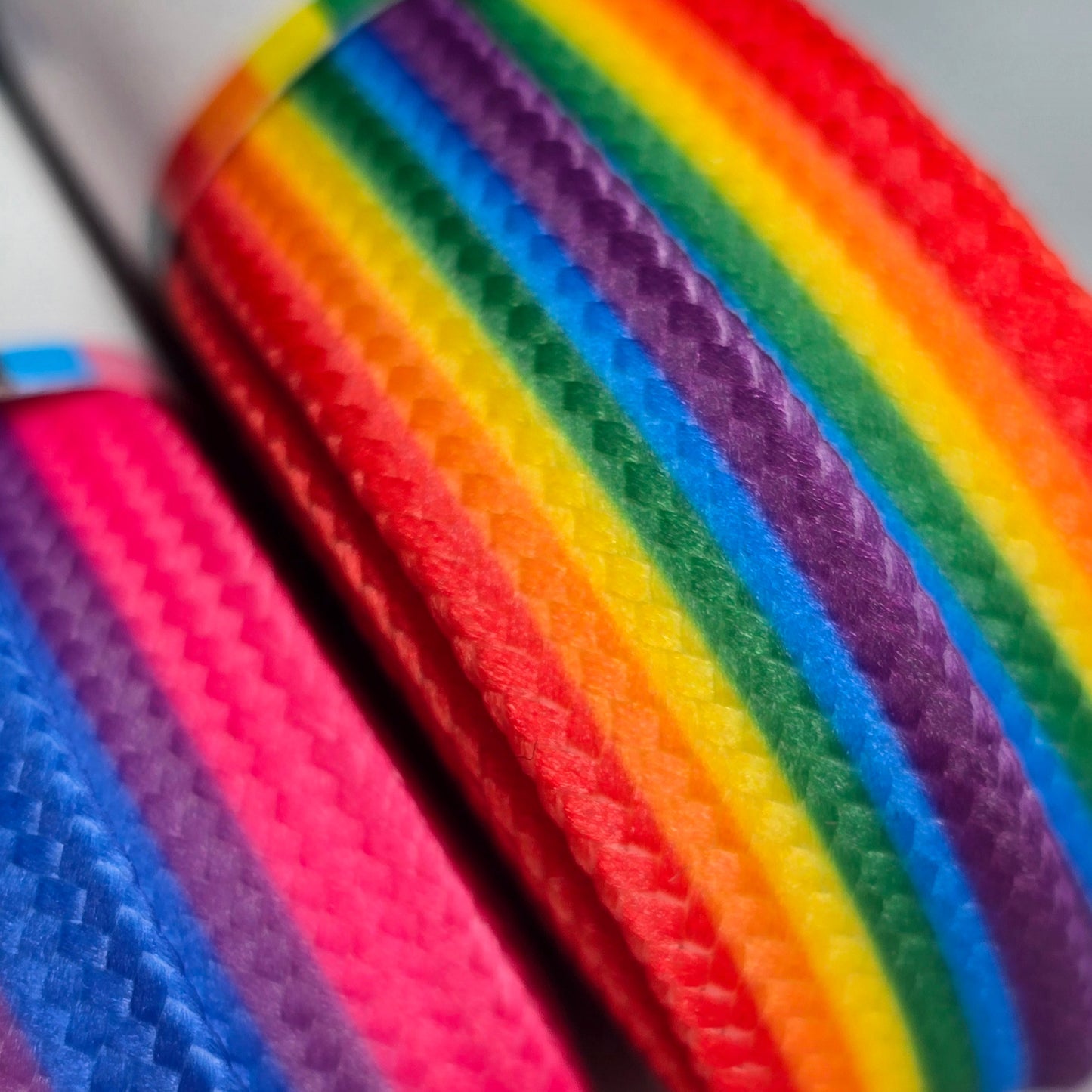 Close-up of Waxed Skate Laces in Rainbow and Pride Flag designs—braided, durable, and performance-waxed—arranged in parallel lines to create a vibrant, colorful display.