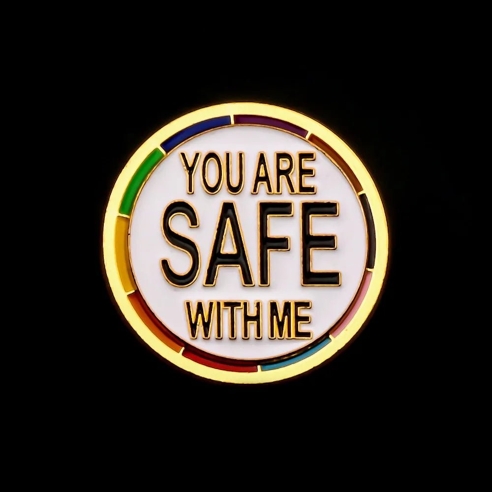 The “You Are Safe With Me - progress pride and gold round pin” features bold black text on white, rainbow segments, and a gold finish—a meaningful piece for your pride collection.