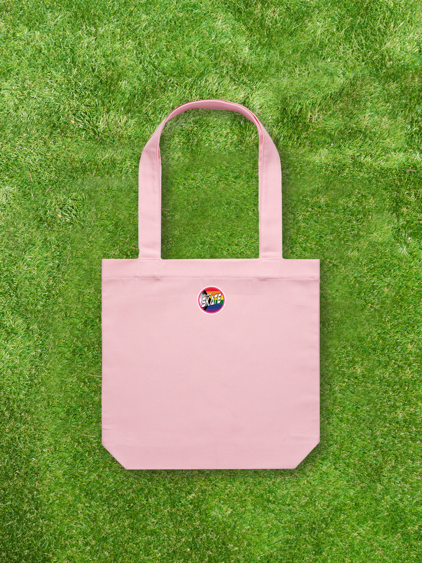 A Large printed Cotton Canvas Tote Bag in pink from Gay Skate, featuring an original print design with a small rainbow logo. The bag includes two long handles, making it perfect for carrying skates and skate gear.