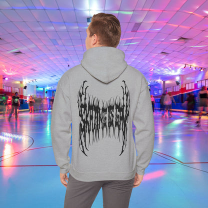 A person wearing the "SKATING IS GAY but make it death metal" hoodie stands in a brightly lit roller skating rink. The rink is adorned with colorful lights, and other people are skating in the background.