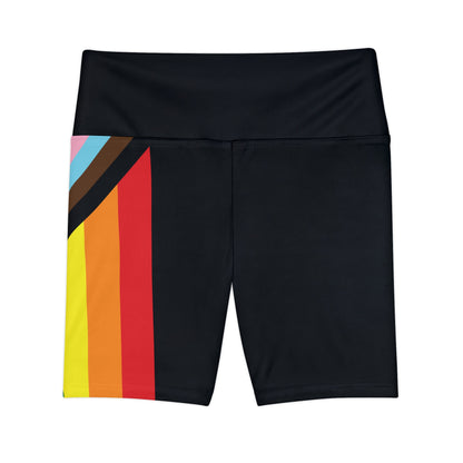 A person wearing Printify's Progress Pride Rainbow Flag High-Waisted Workout Pants, featuring a vibrant design perfect for an active lifestyle. The shorts display horizontal stripes in black, brown, light blue, pink, white, red, orange, yellow, green, and blue against a white background.