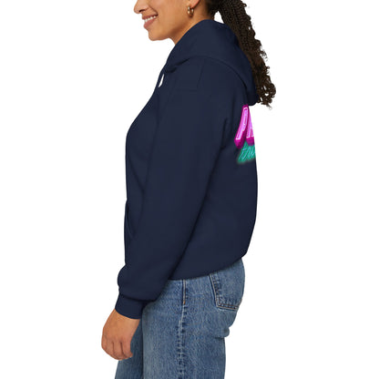 A person wears the "Protect Trans Kids" navy unisex hoodie, made from ethically grown cotton, featuring colorful back text. They pair it with blue jeans, smile sideways with a ponytail against a white background.