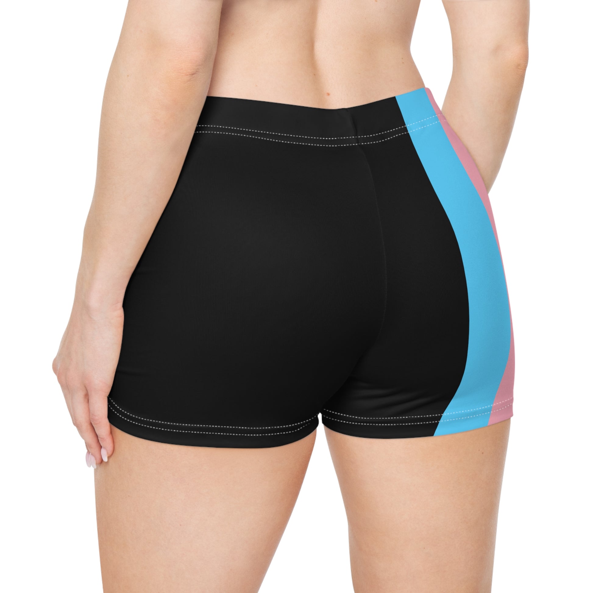 A person wearing Printify's Transgender Pride Flag Short Shorts, which feature the horizontal stripes of light blue, pink, white, pink, and light blue from the transgender pride flag. Made from a moisture-wicking polyester spandex blend, these high-waisted shorts reveal the person's bare midriff and upper thighs.