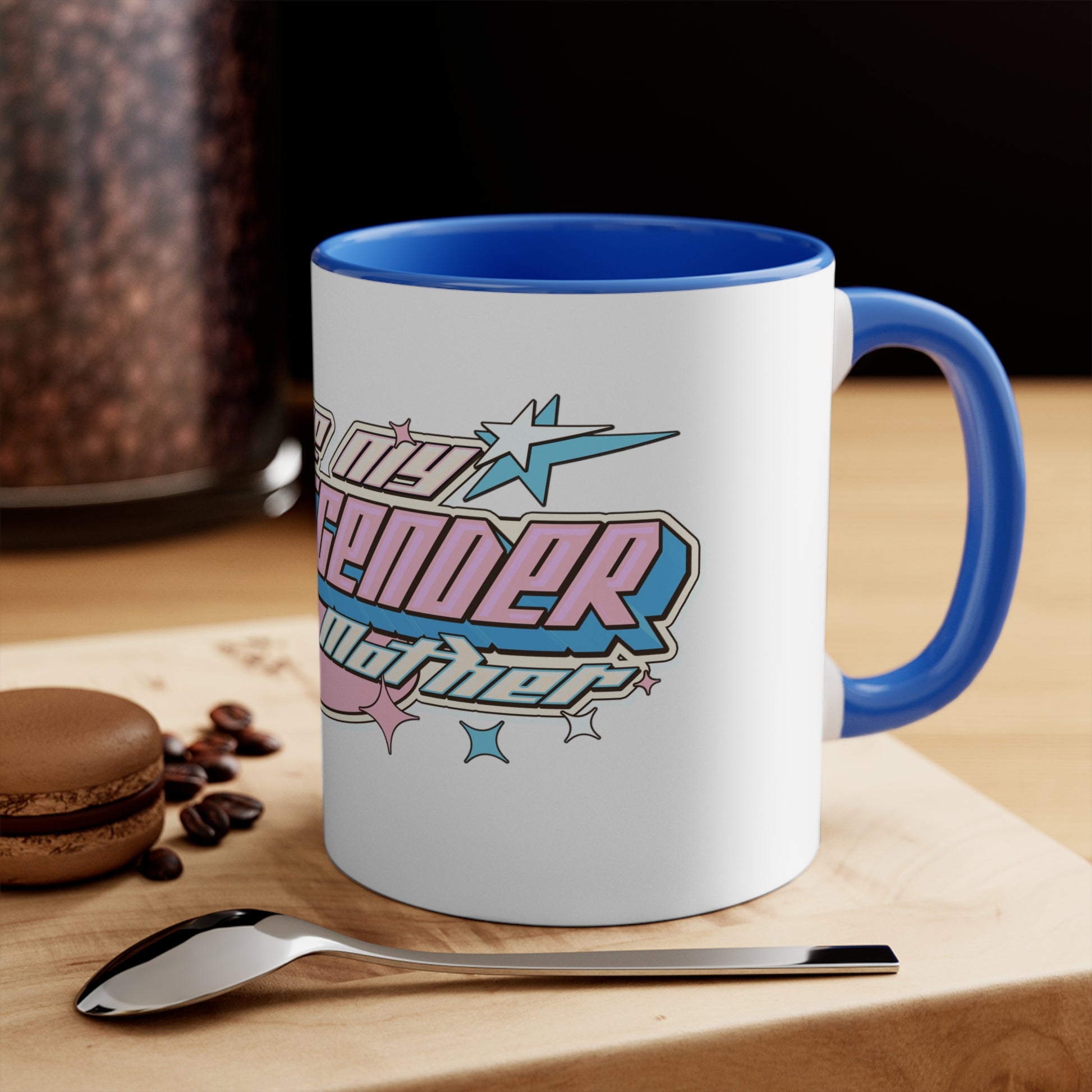 The I Love My Transgender Mother original design accent mug from Printify is a white ceramic mug featuring a pink interior. It displays colorful, stylized text in pink and blue with a 3D effect that reads "I love my transgender mother." The design is highlighted with star motifs and set against a vibrant background.