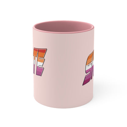 The SKATE lesbian pride flag accent mug by Printify features a bold "SKATE" design in gradient colors of orange, pink, and purple. This eye-catching ceramic mug boasts a light pink handle and interior that beautifully contrast with its pale pink exterior.