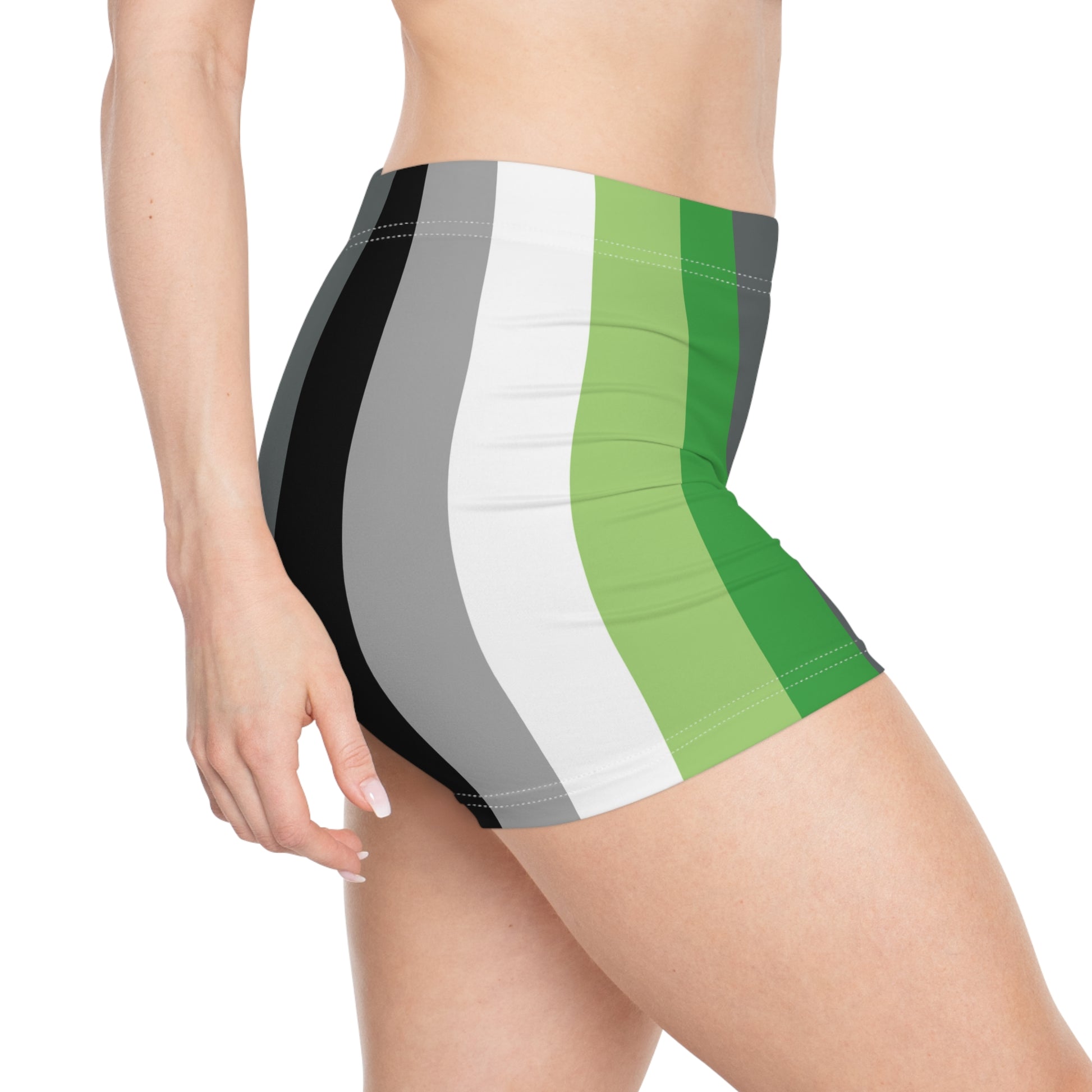 A person is shown from the side wearing Gay Skate's Aromantic Pride Flag Short Shorts, featuring vertical stripes in black, grey, white, green, and dark green. The unisex activewear shorts fit snugly. A great look for festivals, clubbing, roller derby or the gym.