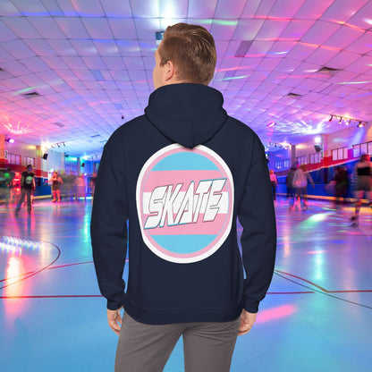 A person wearing a high-quality, unisex "Gay Skate Original - Trans Edition Hoodie" from Printify, featuring a large "SKATE" logo on the back, stands in a colorful roller skating rink. The rink is illuminated with multicolored lights and has several people skating in the background. The overall atmosphere is lively and vibrant.