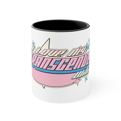 The Printify "I Love My Transgender Wife" original design accent mug is a white ceramic mug with a pink interior, showcasing a retro-styled design of pink, blue, and white stripes. The text on the mug reads "I LOVE MY TRANSGENDER LIFE" surrounded by colorful stars.