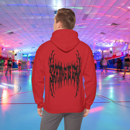 A person wearing the "SKATING IS GAY but make it death metal" hoodie stands in a brightly lit roller skating rink. The rink is adorned with colorful lights, and other people are skating in the background.