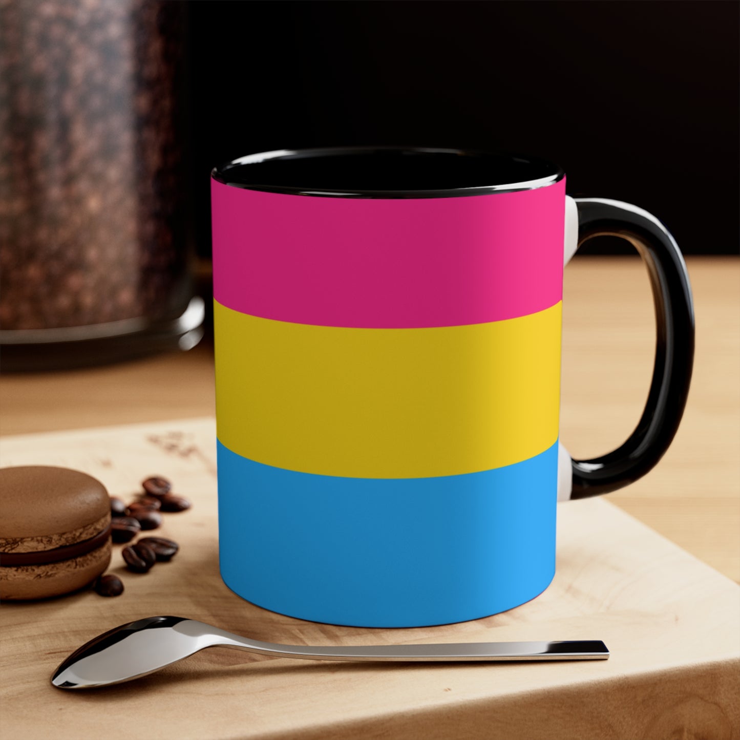 The Pansexual Pride Flag colourful accent mug from Printify features a ceramic design with a pink handle and colorful interior that showcases the colors of the pan pride flag: pink on top, yellow in the middle, and blue on the bottom.