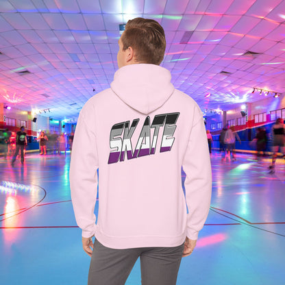 A person wearing a Printify SKATE Asexual Pride Hoodie, featuring the word "SKATE" printed on the back in gradient colors, stands in a brightly lit roller skating rink, observing the skaters. The rink is illuminated with colorful lights and exudes a lively atmosphere.