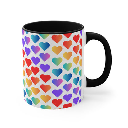 The Rainbow Pride Love Hearts Colorful Accent Mug by Printify is a white mug with a red handle and a colorful interior, adorned with a vibrant pattern of gradient hearts. The hearts transition through various colors, creating an eye-catching color contrast against the white background.