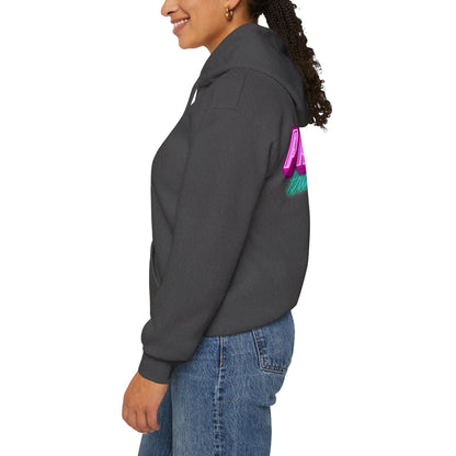 Wearing the unisex Protect Trans Kids Hoodie in dark gray, featuring colorful back text, a person stands in profile. Their curly hair is pulled back, and they wear it with blue jeans. Crafted from ethically grown cotton, the hoodie contrasts against the plain white background.