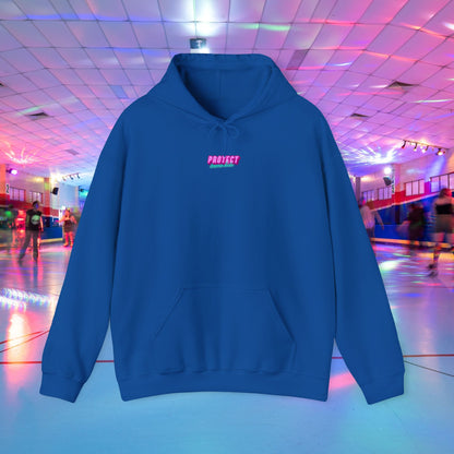 Displayed is the "Protect Trans Kids" unisex heavy blend hoodie, featuring "PROTECT" in pink across the chest. Made from ethically grown cotton, it stands out against a colorful roller skating rink backdrop with vibrant lights and skaters.