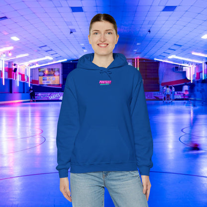 An individual in an ethically made "Protect Trans Kids" unisex hoodie stands amidst vibrant pink and blue neon lights in an indoor roller skating rink.