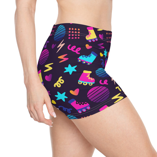 The person is wearing the Retro Roller Skate Short Shorts, a creation from GAY SKATE, a queer-owned small business. These shorts boast a vibrant 1980s graphic rainbow pattern featuring skates, stars, hearts, circles, and lightning bolts in neon colors against a dark background.