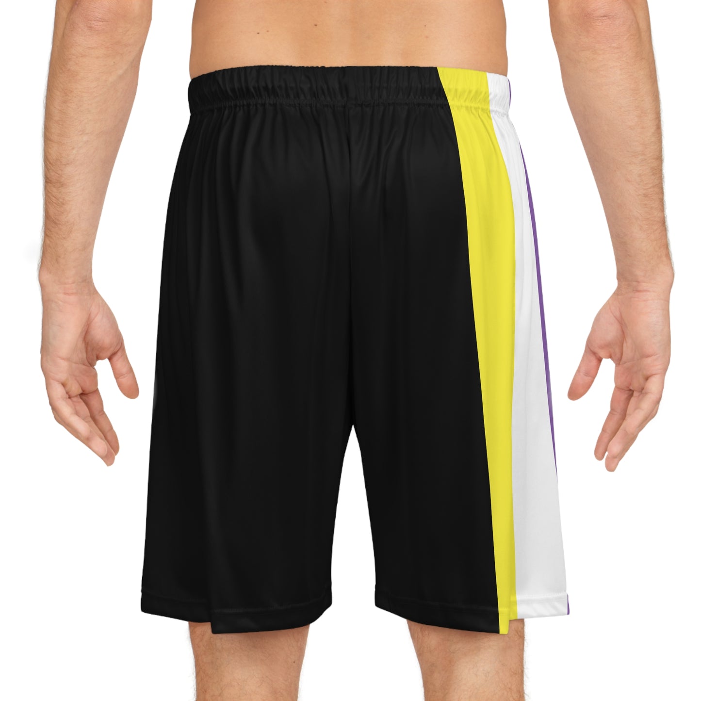 A person is standing wearing Non-Binary Pride Flag Basketball Shorts - Black from Printify, featuring an elastic waistband and side panels in vertical stripes of white, yellow, purple - thr nonbinary pride flag. The individual is shirtless, showing their midsection and a portion of their legs.