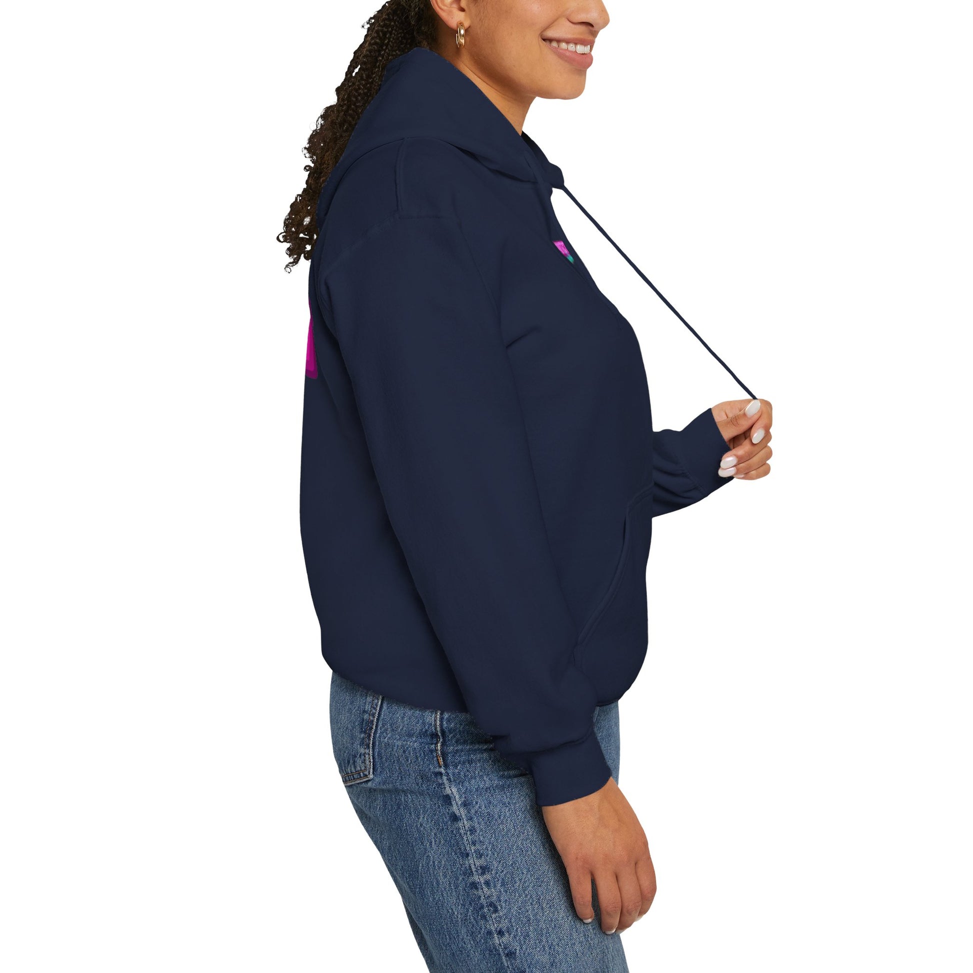 Wearing the Protect Trans Kids Hoodie, a person with long curly hair tied back smiles and holds the drawstrings. They're dressed in jeans, standing side-on against a white background, highlighting the hoodie made from ethically grown cotton.