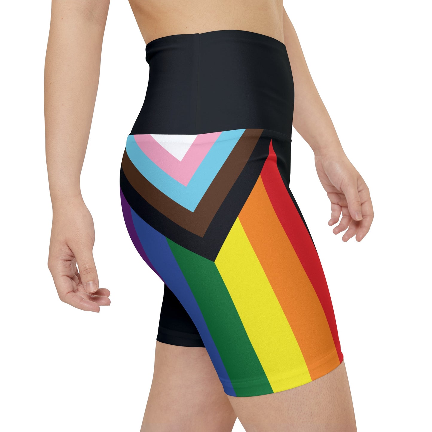 A person wearing Printify's Progress Pride Rainbow Flag High-Waisted Workout Pants, featuring a vibrant design perfect for an active lifestyle. The shorts display horizontal stripes in black, brown, light blue, pink, white, red, orange, yellow, green, and blue against a white background.