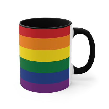 The Rainbow Pride Flag Colorful Accent Mug by Printify is a white ceramic mug featuring a red handle and interior. The exterior showcases horizontal stripes in the vibrant colors of the LGBTQ+ pride flag—red, orange, yellow, green, blue, and purple—offering a striking color contrast.