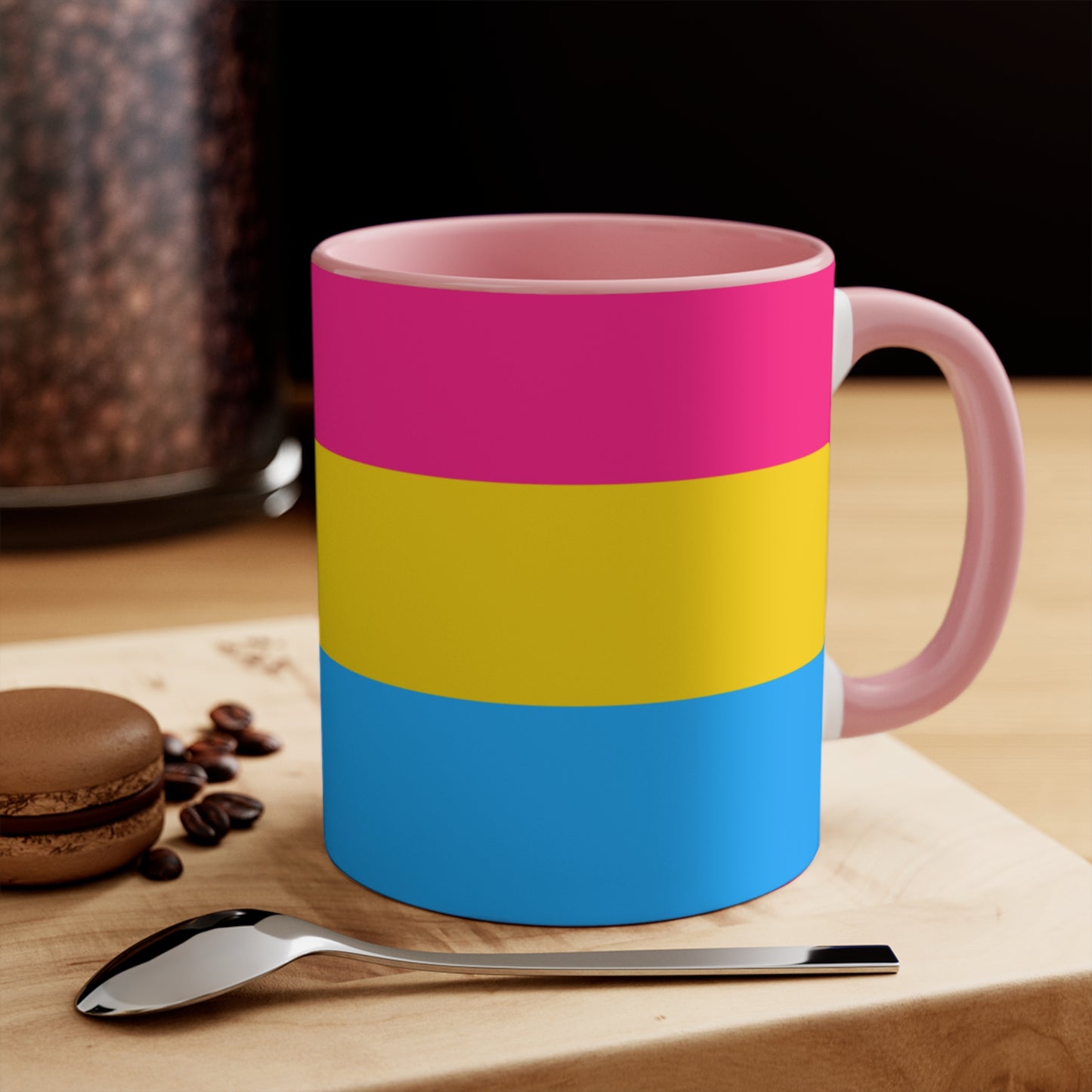 The Pansexual Pride Flag colourful accent mug from Printify features a ceramic design with a pink handle and colorful interior that showcases the colors of the pan pride flag: pink on top, yellow in the middle, and blue on the bottom.