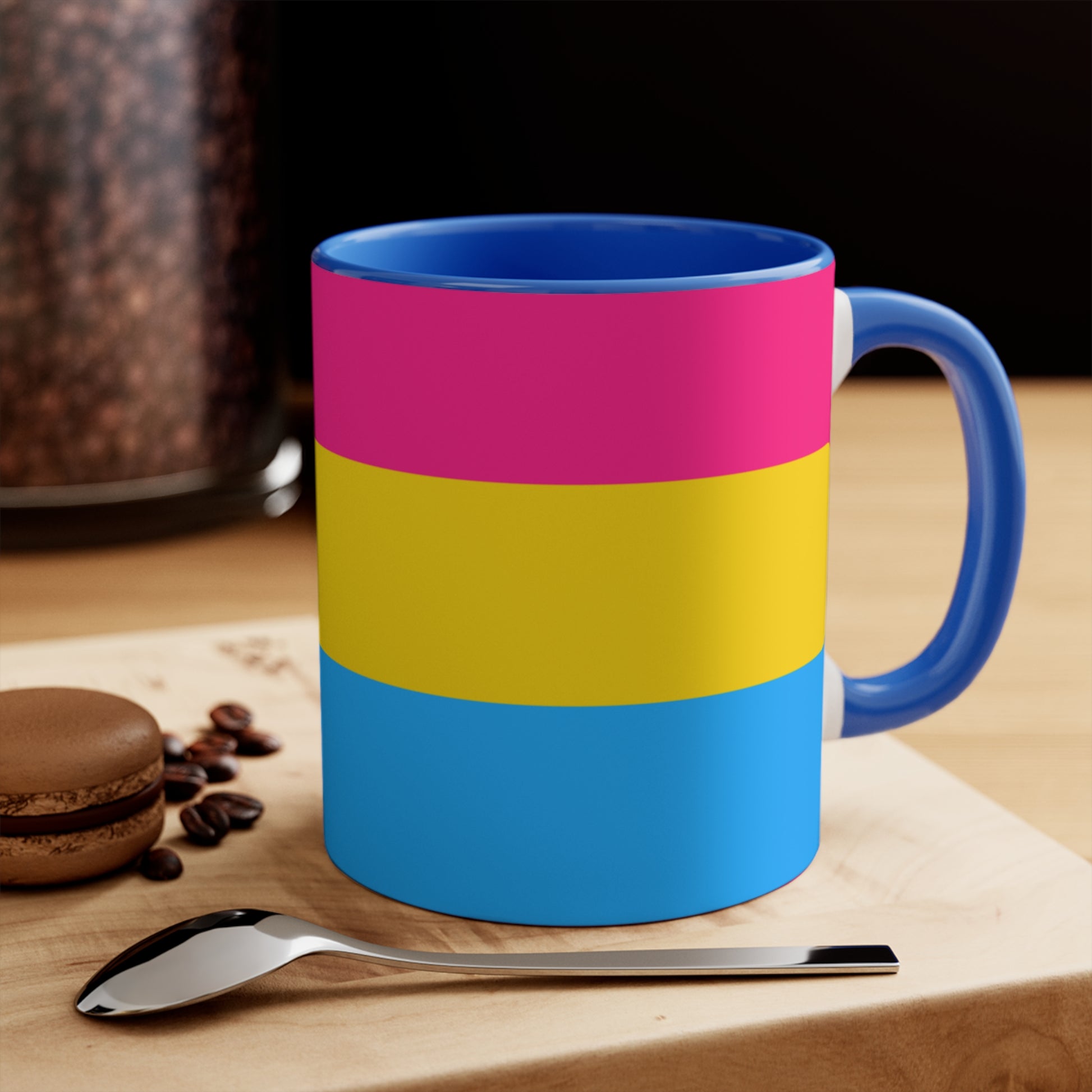 The Pansexual Pride Flag colourful accent mug from Printify features a ceramic design with a pink handle and colorful interior that showcases the colors of the pan pride flag: pink on top, yellow in the middle, and blue on the bottom.