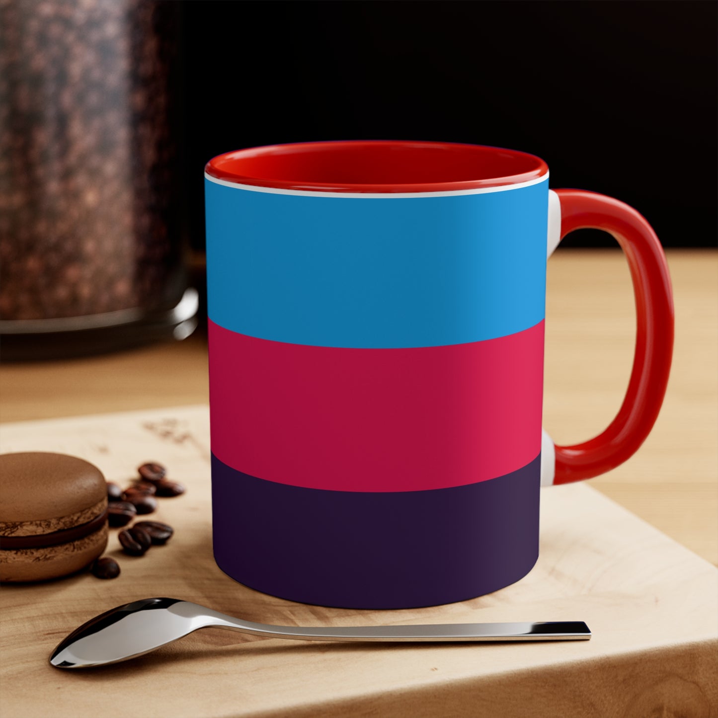 The Polyamory Pride Flag cup - colorful accent mug by Printify features a white coffee mug with a red handle and a vibrant interior. The exterior design showcases a colorful heart on a white background, accompanied by distinctive elements including a blue triangle, pink stripe, and purple stripe.