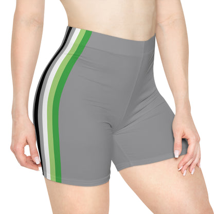 A person is wearing Aromantic Pride Flag Bike Shorts, featuring gray shorts with vertical stripes in black, white, dark green, and light green on the side. The photo focuses on their lower torso, buttocks, and upper portion of the legs, highlighting the moisture-wicking fabric of the shorts.