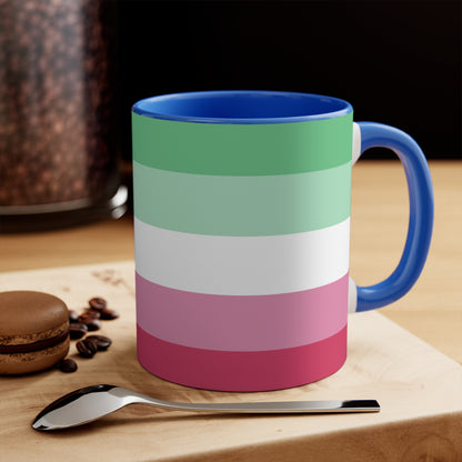 The Abro, Abroromantic, Abrosexual pride flag Accent Mug by Printify is a ceramic mug designed with horizontal stripes in green, light green, white, pink, and red to reflect the vibrant hues of the Abrosexual pride flag. It also features a pink handle and a colorful interior.