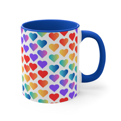 The Rainbow Pride Love Hearts Colorful Accent Mug by Printify is a white mug with a red handle and a colorful interior, adorned with a vibrant pattern of gradient hearts. The hearts transition through various colors, creating an eye-catching color contrast against the white background.