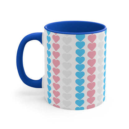 The Trans pride flag love hearts colourful accent mug by Printify features a white exterior adorned with vertical rows of pink, blue, and white hearts, reminiscent of the trans pride flag. Its cheerful and colorful appearance is enhanced by the pink handle and inner rim.