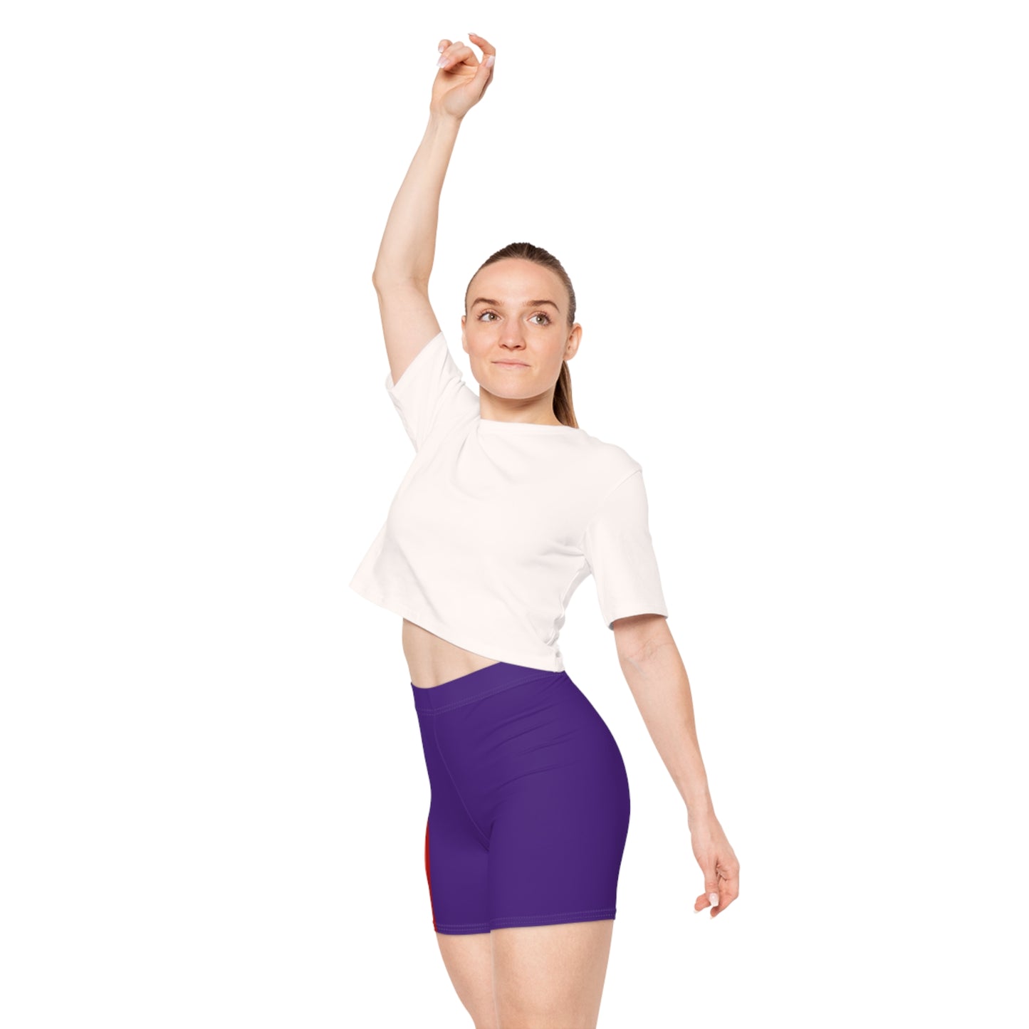 A person is wearing Rainbow and Purple Bike Shorts, which feature a bold, vertical rainbow pride flag stripe pattern on the side in red, orange, yellow, green, blue, and purple. These form-fitting shorts are made from moisture-wicking polyester spandex and have a neutral white background.