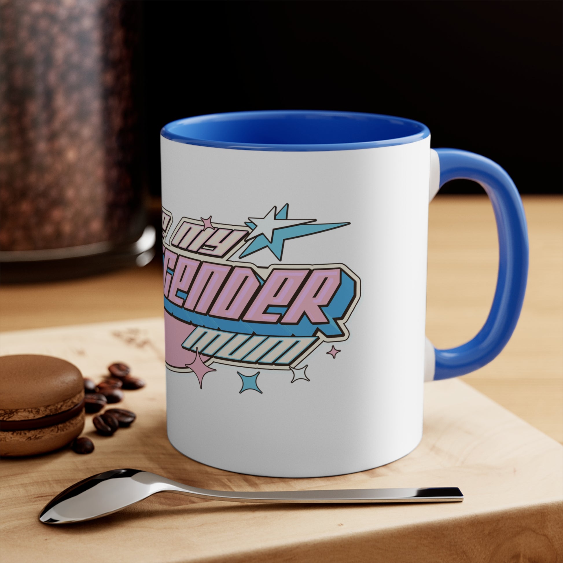 The "I Love My Transgender Mum" original design accent mug by Printify is a white ceramic mug with a vibrant pink interior. It features the stylized word "Transcend," adorned with stars and gradient shades of pink, blue, and purple that represent the colors of the transgender pride flag.