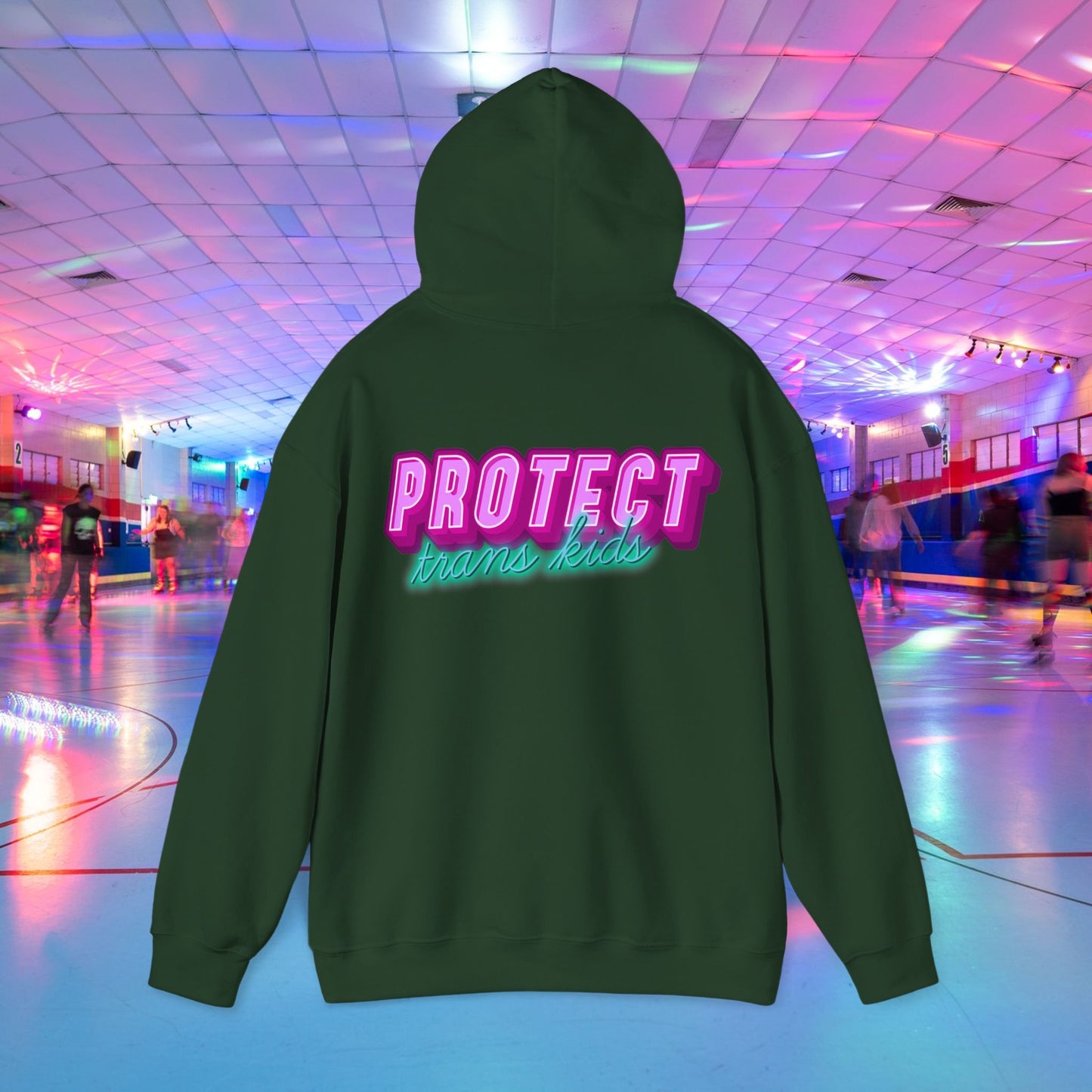 The "Protect Trans Kids" Hoodie (Australian Shipping) features bold pink and teal lettering on a green unisex heavy blend. It's made from ethically grown cotton and provides comfort and style against a vibrant, neon-lit roller skating rink backdrop.