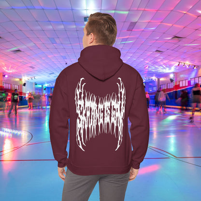 A person wearing the "SKATING IS GAY but make it death metal" hoodie stands in a brightly lit roller skating rink. The rink is adorned with colorful lights, and other people are skating in the background.